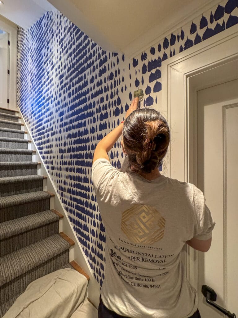 Professional wallpaper installer applying a patterned wallcovering